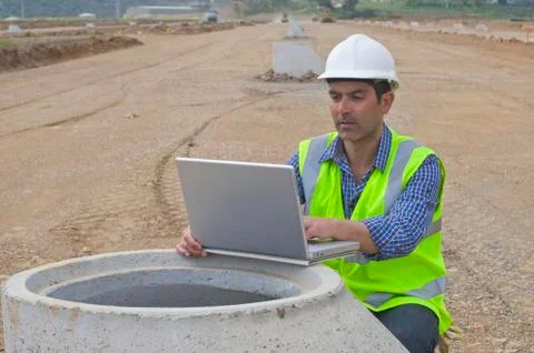 Hispanic construction worker using laptop in field Stock Photos