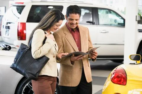 Hispanic couple at car dealership Stock Photos