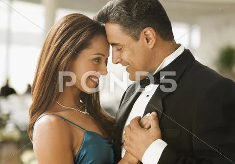 Hispanic couple dancing in eveningwear Stock Photos