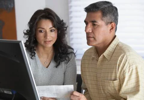 Hispanic couple looking at computer Stock Photos