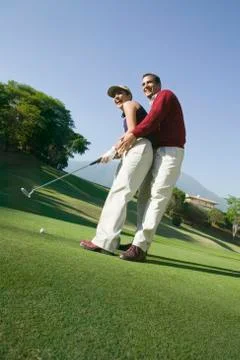 Hispanic couple playing golf Photos