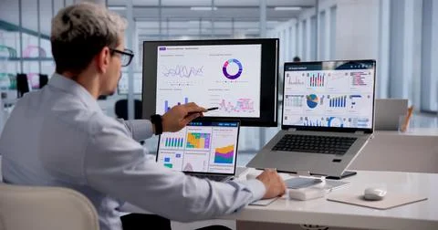 Hispanic Data Analyst Analyzing Financial Graphs On Laptop For Market Strateg Foto stock
