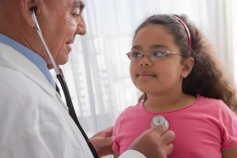 Hispanic doctor checking patient's heartbeat Stock Photos