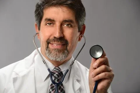 Hispanic doctor using stethoscope Stock Photos