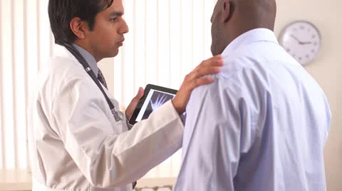 Hispanic doctor using tablet pc to share x-rays with patient Video stock 26157913