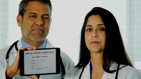 Hispanic doctors show us a tablet with 4 things to do to avoid spreading viruses Video stock 127127453
