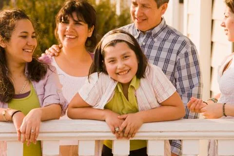 Hispanic family leaning on porch railing Stock Photos