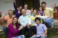 Hispanic family sitting on steps together waving Stock Photos