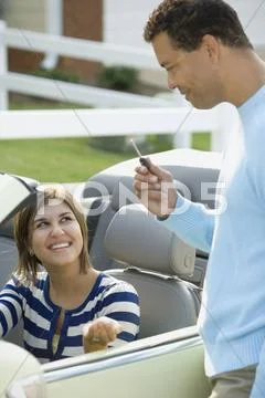 Hispanic father giving daughter car key Stock Photos