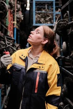 Hispanic female inspector checking auto parts stock in a warehouse stack. Stock Photos