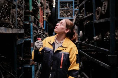 Hispanic female inspector checking auto parts stock in a warehouse stack. Foto stock