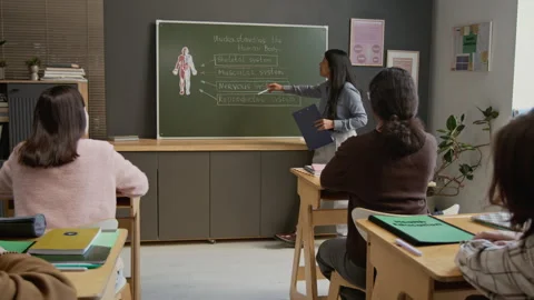 Hispanic Female Teacher Explaining Human Body Systems to Students Stock Footage 333763160