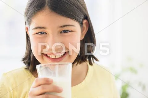 Hispanic Girl Drinking Glass Of Milk