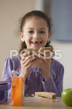 Hispanic girl eating lunch at school Stock Photos