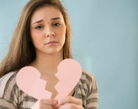 Hispanic girl holding broken heart shape Stock Photos