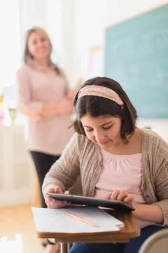 Hispanic girl using digital tablet in classroom 写真素材