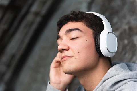 Hispanic handsome teenager listening to music Stock Photos