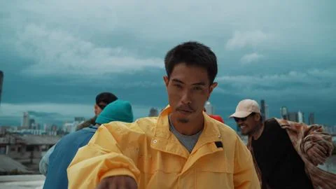 Hispanic hipster looking at camera surrounded by friend at rooftop. Hiphop. 写真素材