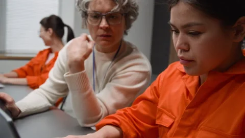 Hispanic Inmate Using Laptop during Computer Class with Female Teacher Stock Footage 328999605