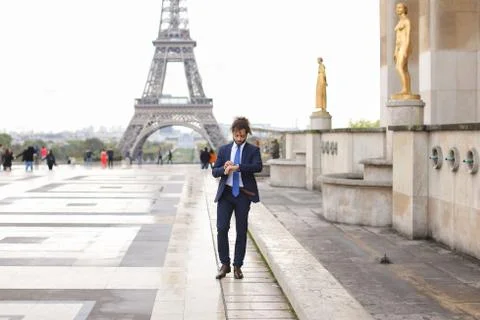 Hispanic journalist close to Eiffel Tower reading newspaper and Фото