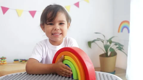 Hispanic little girl playing with development rainbow toy at preschool classroom Stock-Footage 332803553