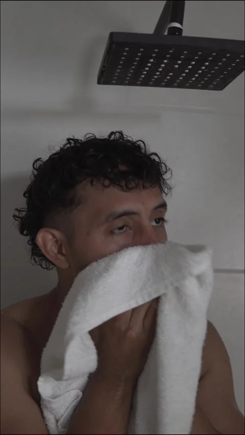 Hispanic male drying himself with a towel after showering Stock Footage 336975196