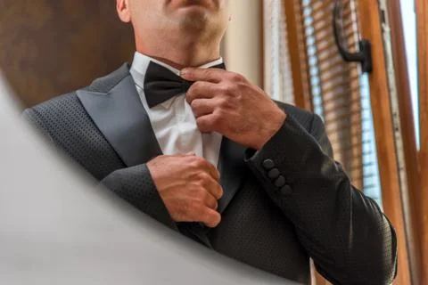 Hispanic man adjusting bowtie Stock Photos