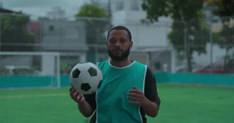 Hispanic man of African descent holding soccer ball and looking directly at came Video stock 320063047