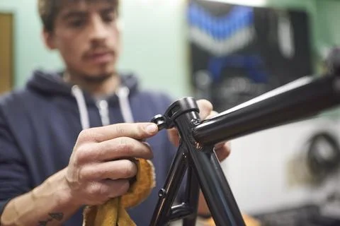 Hispanic man assembling a bicycle in his bike shop during maintenance service Stock-Fotos