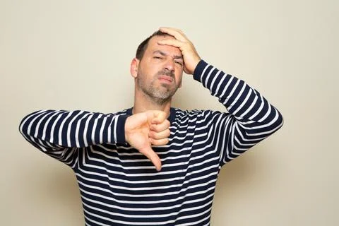 Hispanic man with beard about 40 years old wearing striped sweater looking .. Stock Photos