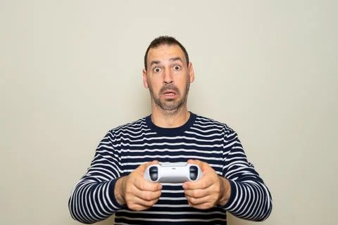 Hispanic man with beard about 40s playing video games with gamepad over iso.. Stock Photos