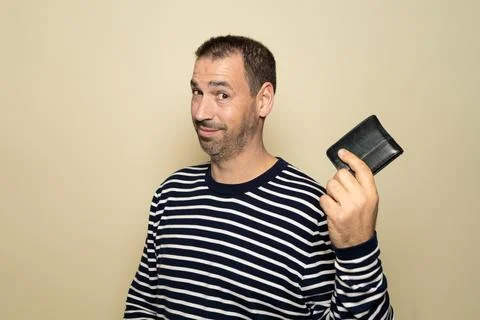 Hispanic man with beard in his 40s wearing a striped sweater smiling and pr.. Stock Photos