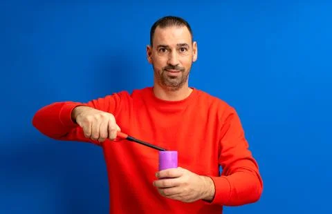 Hispanic man with a beard lighting a purple candle with a kitchen lighter, .. Stock Photos