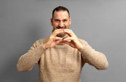 Hispanic man with a beard with the tips of his fingers together in an expre.. Stock Photos
