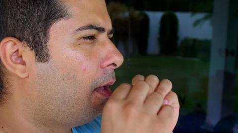 Hispanic Man blowing up violet balloon. Close up Shot Stock Footage 123661725
