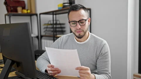 Hispanic man business worker reading document at office Video stock 246143425