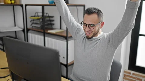 Hispanic man business worker using computer celebrating at office Stock Footage 246143349