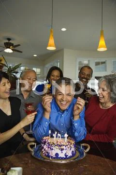 Hispanic Man Celebrating Birthday With Multi-Ethnic Friends