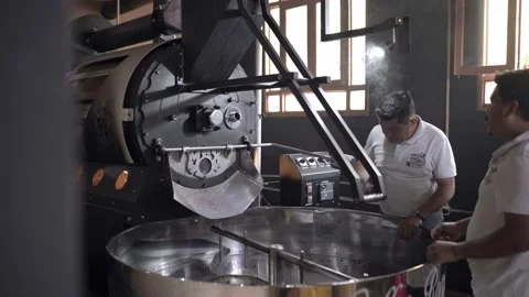 An Hispanic man is checking the beans roast from the coffee roaster machine Stock Footage 219592628