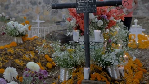 Hispanic man decorating an alter at a grave during Day of the Dead Видео 79570836
