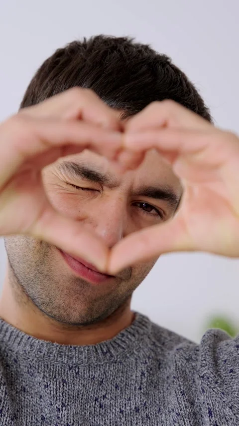 Hispanic man doing heart shape with fingers 스톡 동영상 260656649