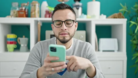 Hispanic man doing online shopping with smartphone at dinning room Video stock 246143291