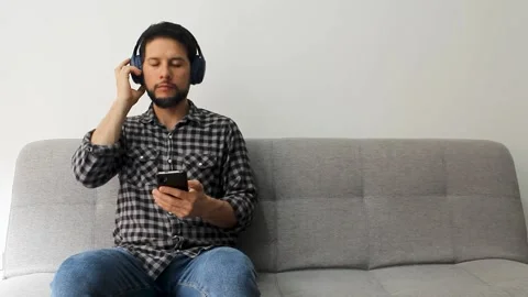 A hispanic man the eyes closed enjoying deeply listen music with a smartphone Vídeo Stock 340583376
