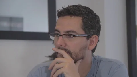 Hispanic man with glasses seriously discussing Stock Footage