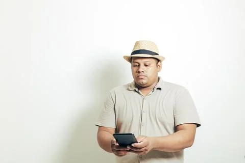Hispanic man with a hat checking his cell phone, on a white background Stock Photos