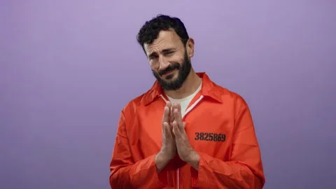 Hispanic man in an orange prison jumpsuit poses with a satisfied expression.. Stock Footage 312816421