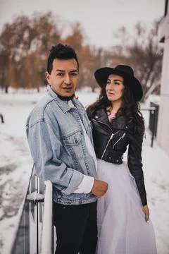Hispanic man in oversized denim jacket and woman in hat leather biker jacket Stock Photos