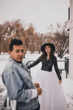 Hispanic man in oversized denim jacket and woman in hat leather biker jacket Stock Photos