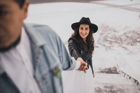 Hispanic man in oversized denim jacket and woman in hat leather biker jacket 스톡 사진