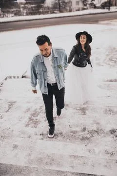 Hispanic man in oversized denim jacket and woman in hat leather biker jacket Stock Photos